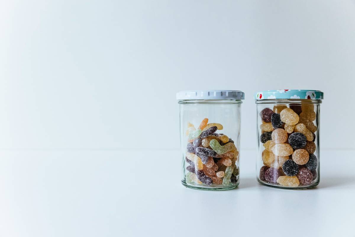 Assorted eco friendly water cups with stainless steel bodies and silicone lids on a kitchen counter